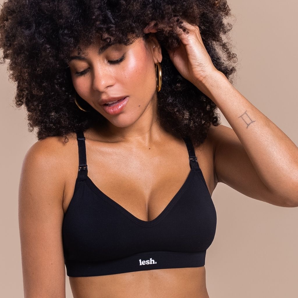 Woman wearing a black bralette with 'lesh' branding on a beige background