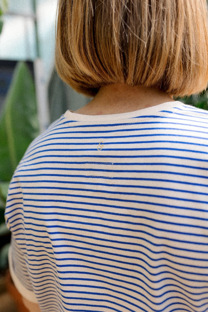 Woman wearing a blue and white striped shirt with blurred background