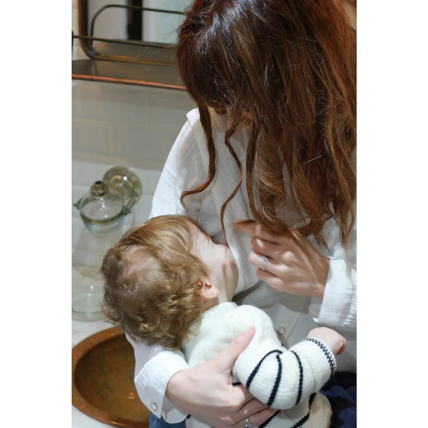Woman breastfeeding a baby through a nursing blouse
