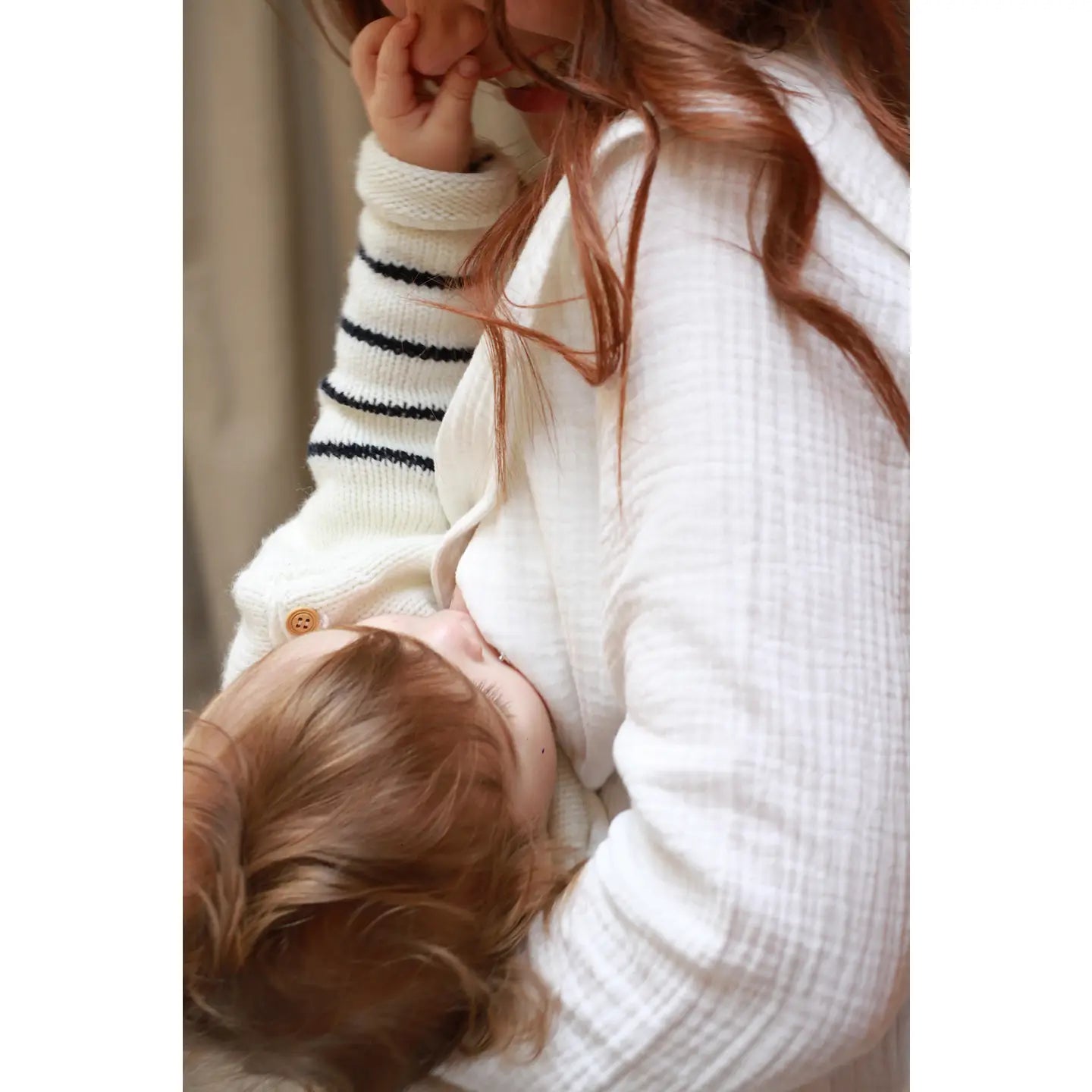 Person with white blouse breastfeeding a baby