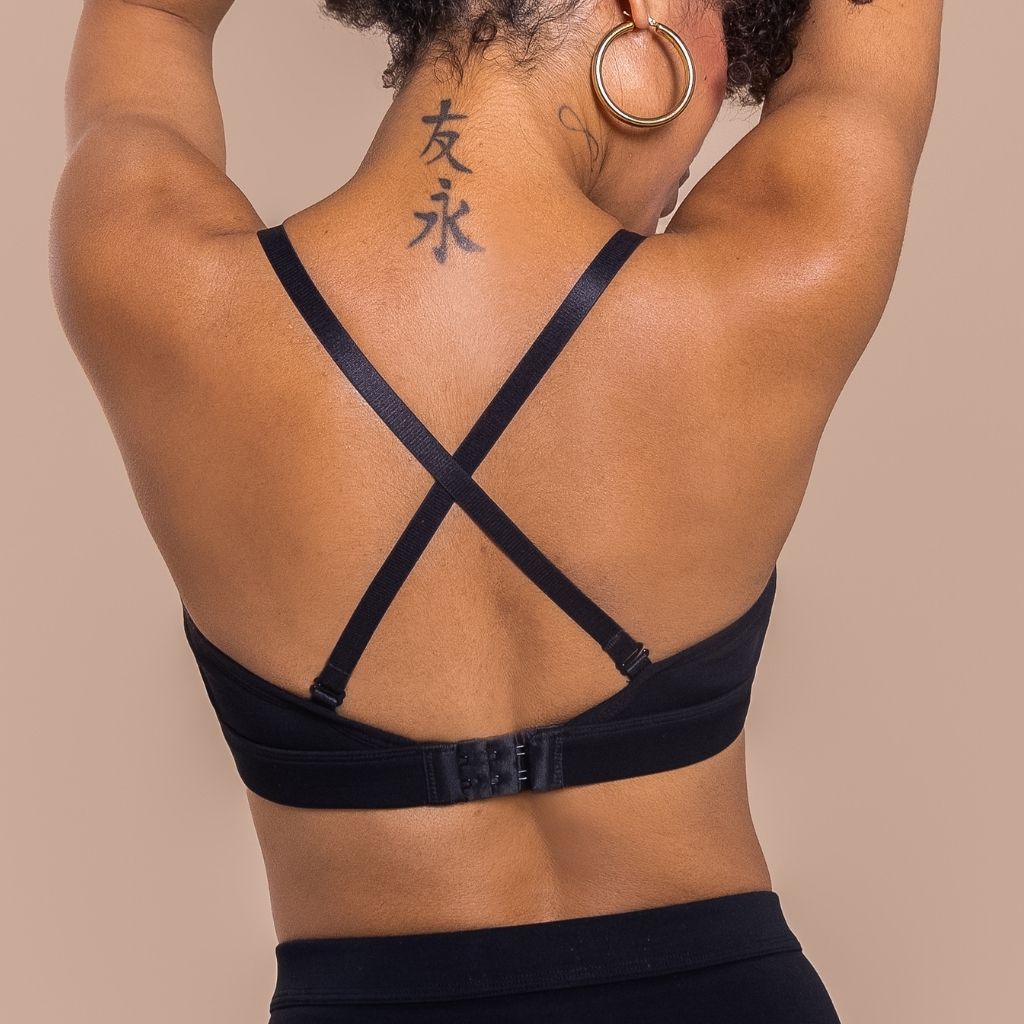the back of a woman wearing a black bra with crossed straps 