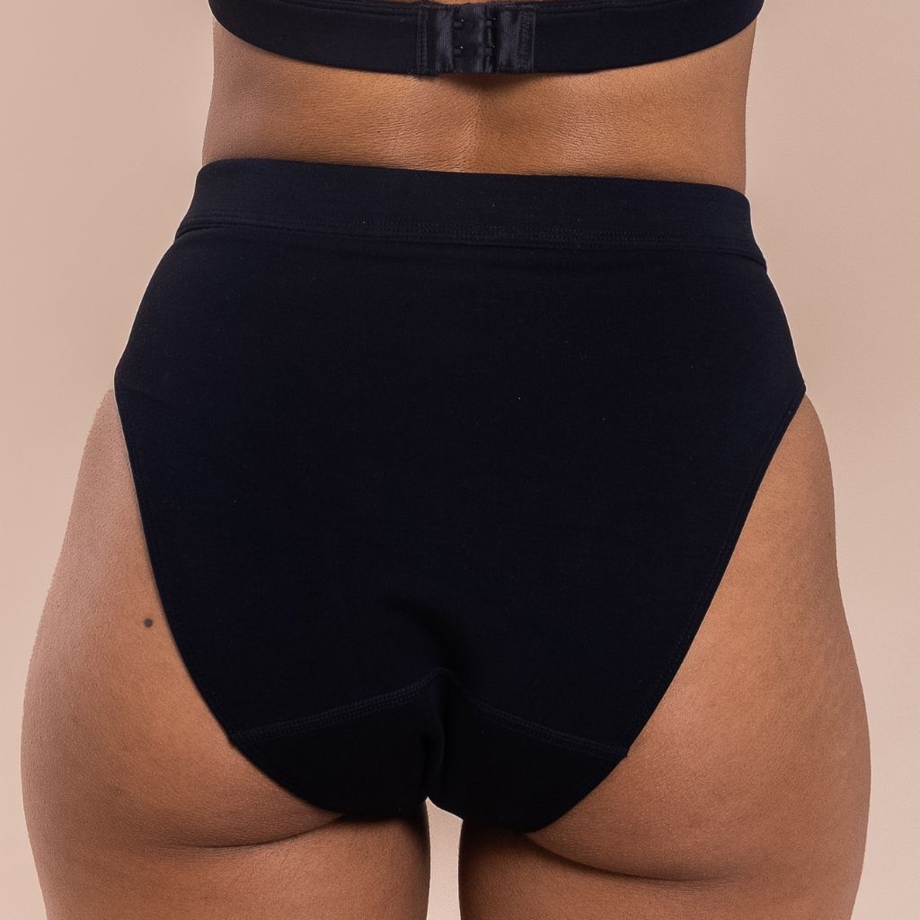 Black high-waisted underwear on a beige background