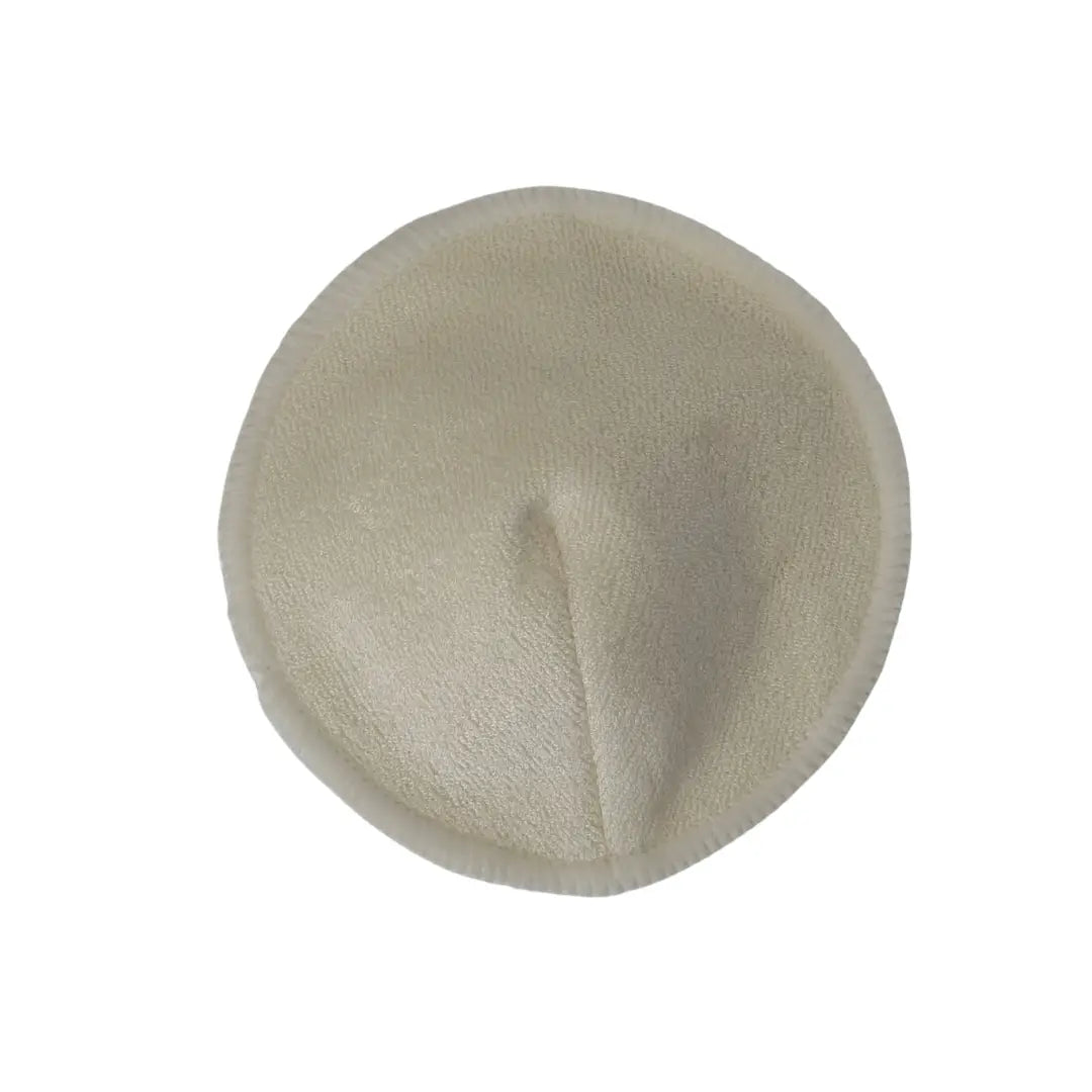 Round beige fabric breast pad on a white background
