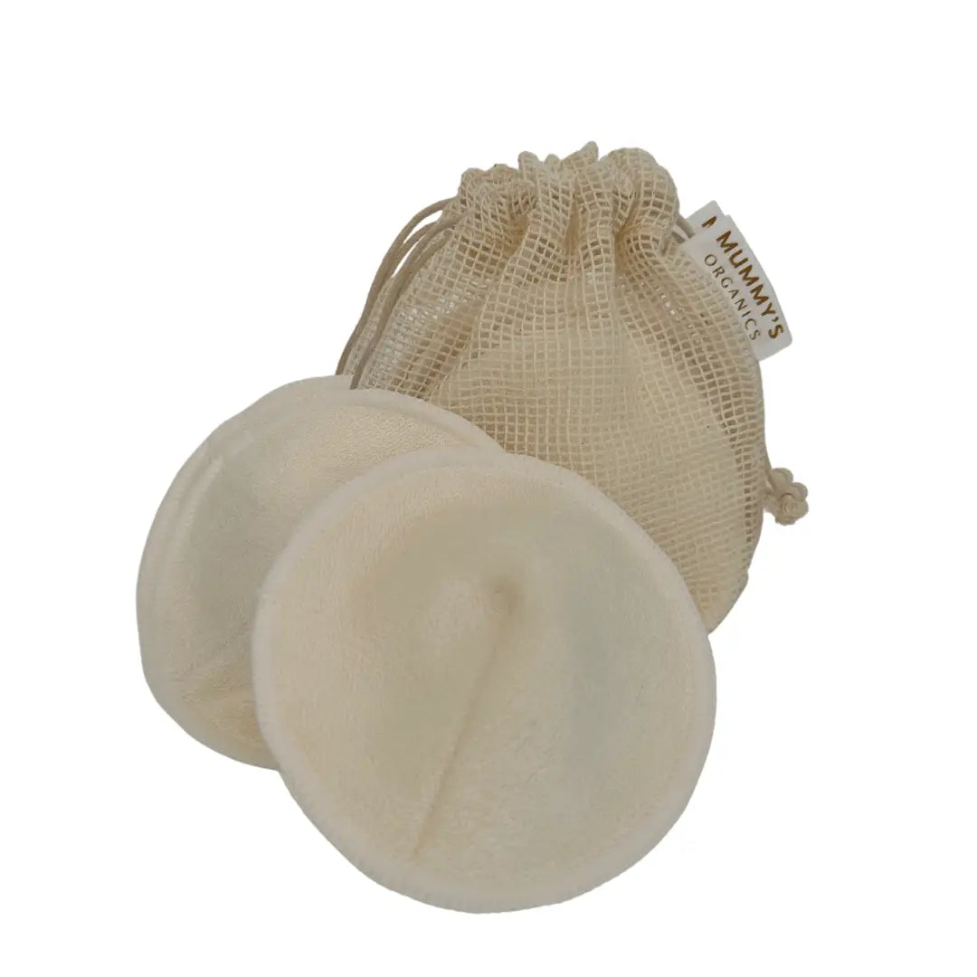 Two beige breast pads with a mesh bag on a white background
