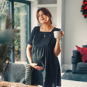 Poppy Mini Dress black linen — side view, oversized smock shape with hidden nursing zip access | Latchette