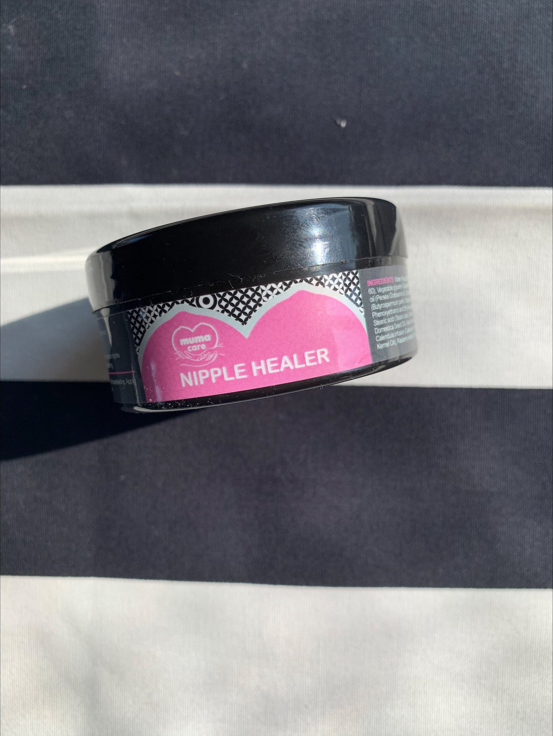 Black container labeled 'Nipple Healer' on a gray background