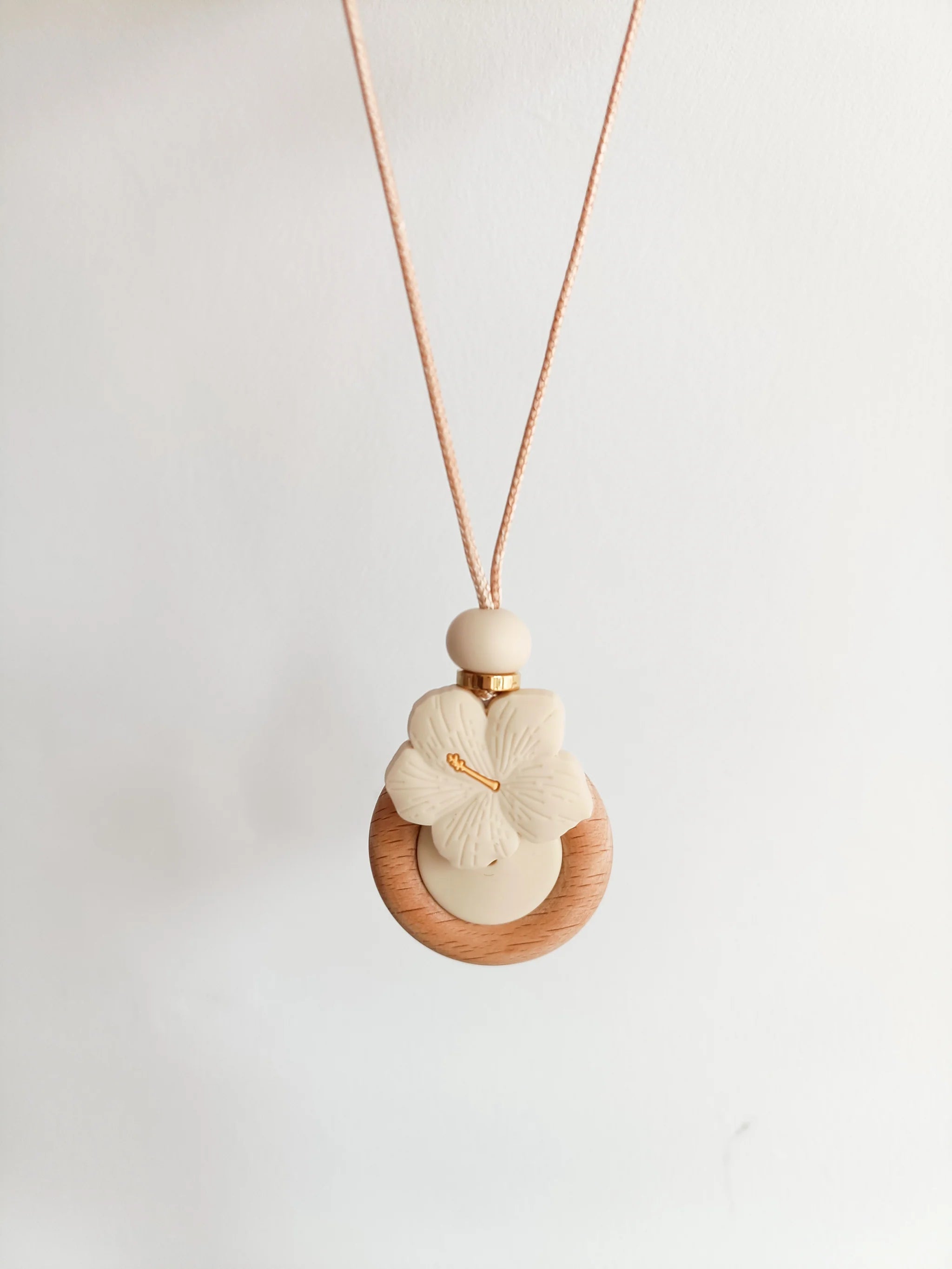 Necklace with wooden pendant and floral design on a light background